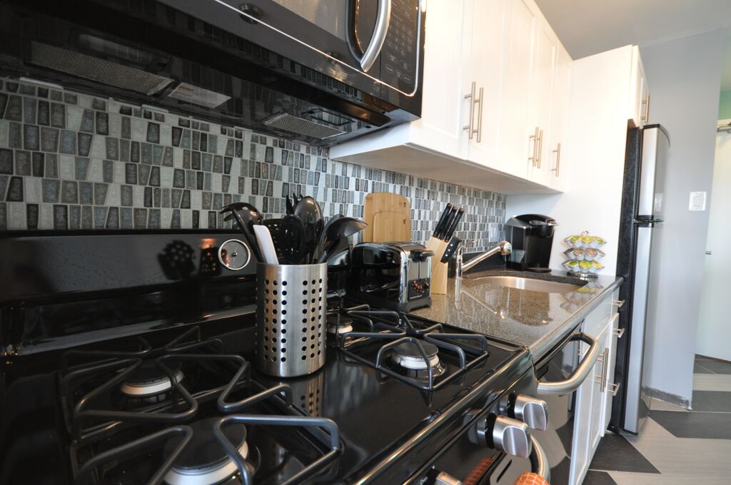 Photo of kitchen stove with gas burners and utensil bin